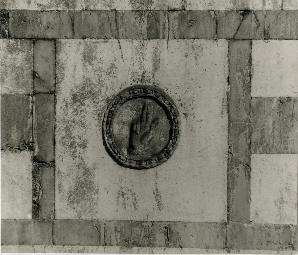 Gasperini M./ Colombo C. , Formella con mano benedicente della facciata del Duomo di Carrara